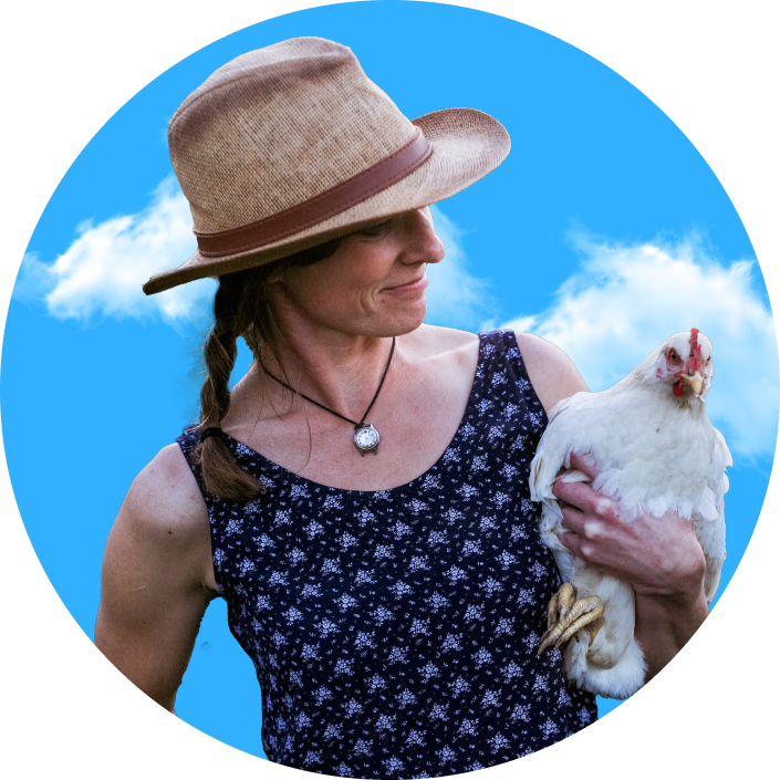 A woman holding a chicken in a hat.