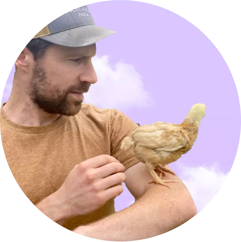 A man holding a chicken in his hand.